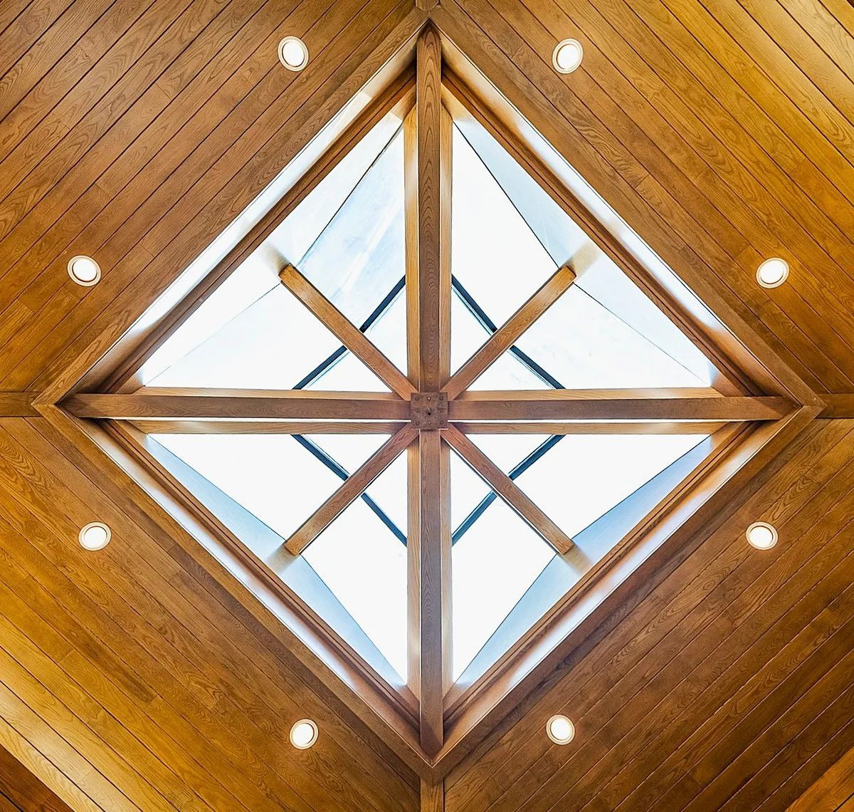 Geometric domed skylight framed in warm timber