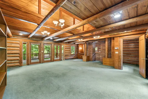 Log cabin great room with river-stone fireplace