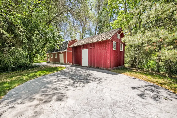 Red outbuilding among the mature trees